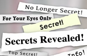 Secrets Revealed words on newspaper headlines to illustrate a co
